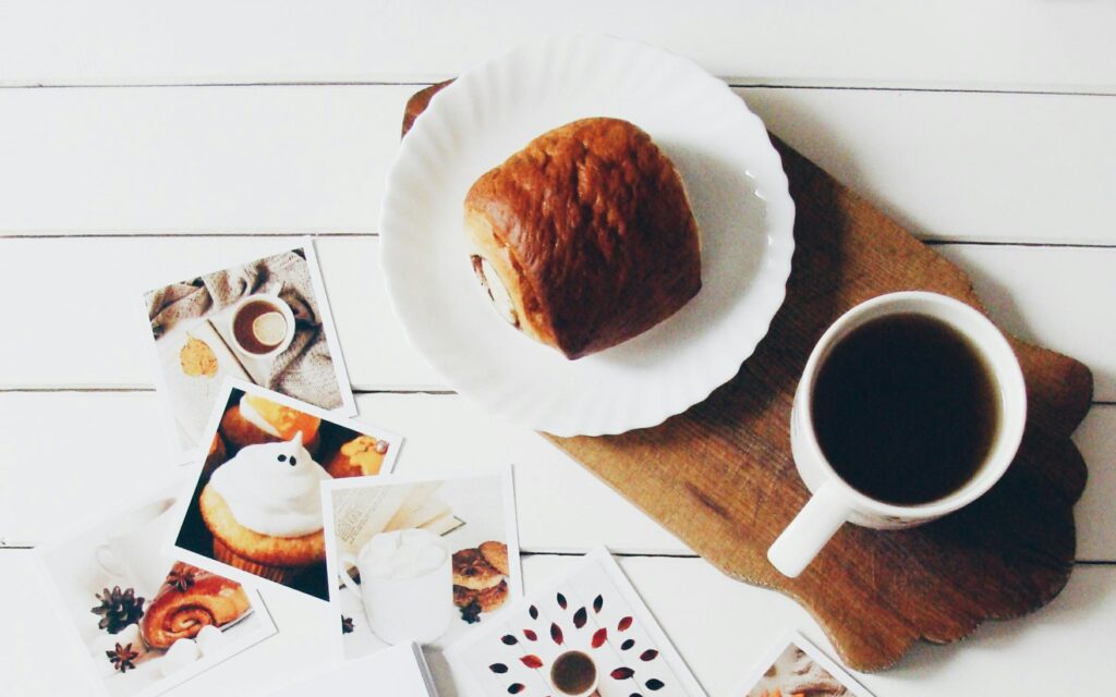 Fotos impresas de comida, café y pan sobre una mesa blanca